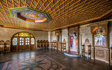 Monastery interior in Meteora with ornate wooden carvings and religious icons.