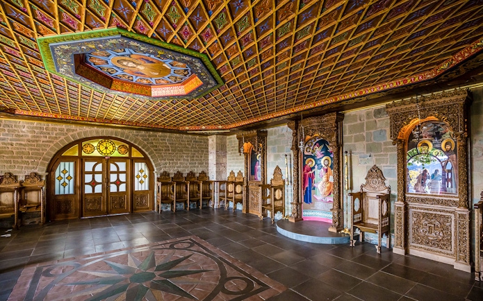 Monastery interior in Meteora with ornate wooden carvings and religious icons.
