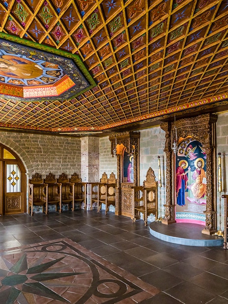 Monastery interior in Meteora with ornate wooden carvings and religious icons.