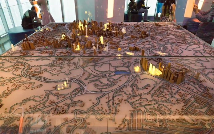 Model of Kuala Lumpur cityscape with illuminated Petronas Twin Towers.