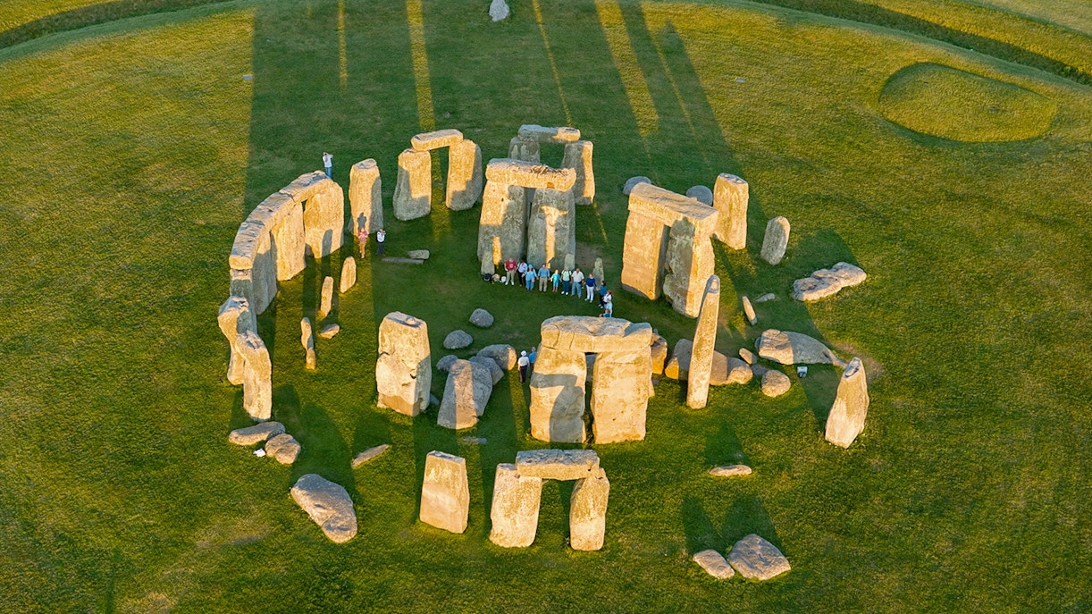 Aerial view of Stonehenge with visitors standing among the ancient stone circle in Wiltshire, England.
