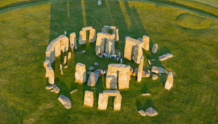 Aerial view of Stonehenge with visitors standing among the ancient stone circle in Wiltshire, England.