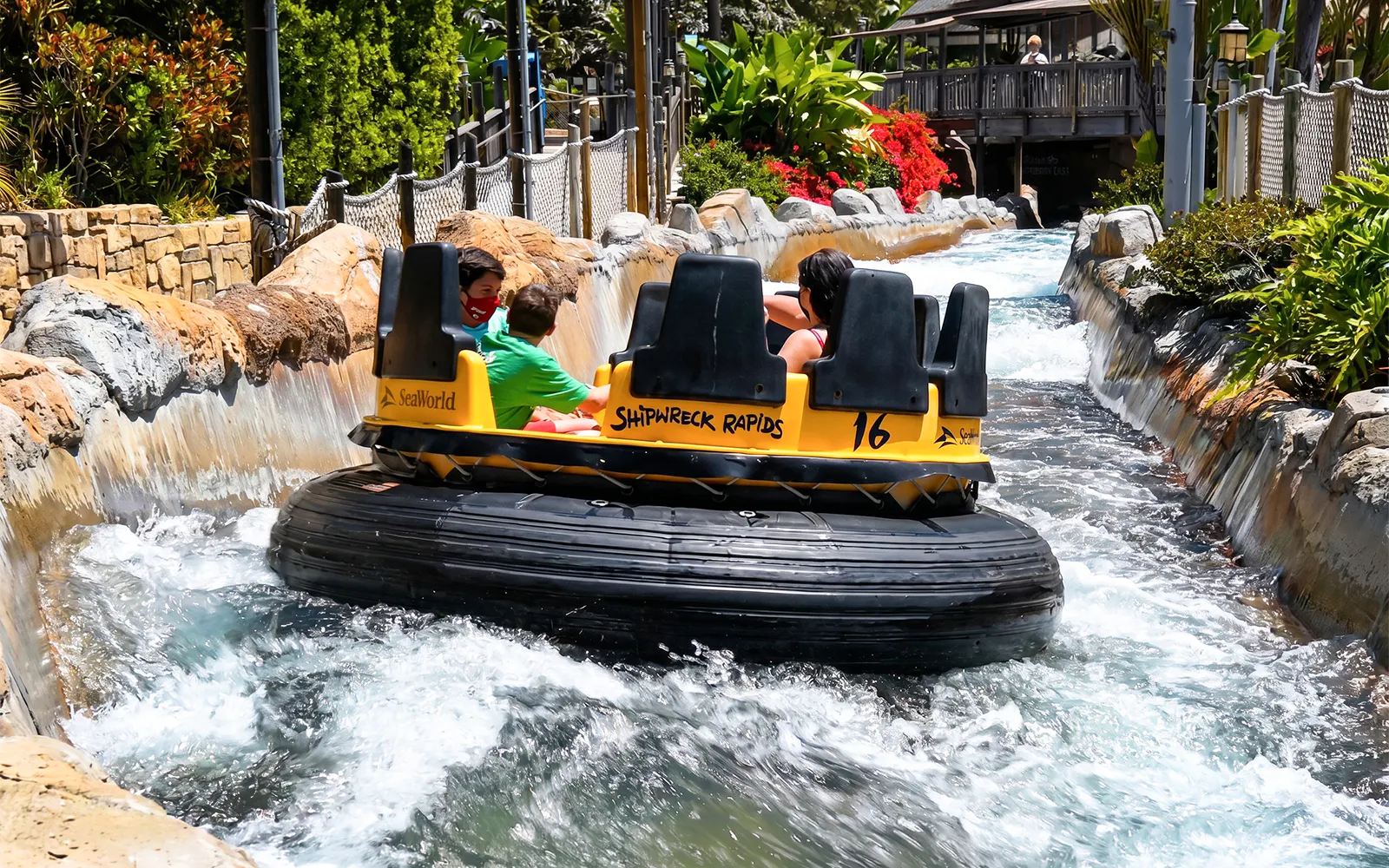 Visitors on Shipwreck Rapids ride at SeaWorld San Diego navigating water rapids.