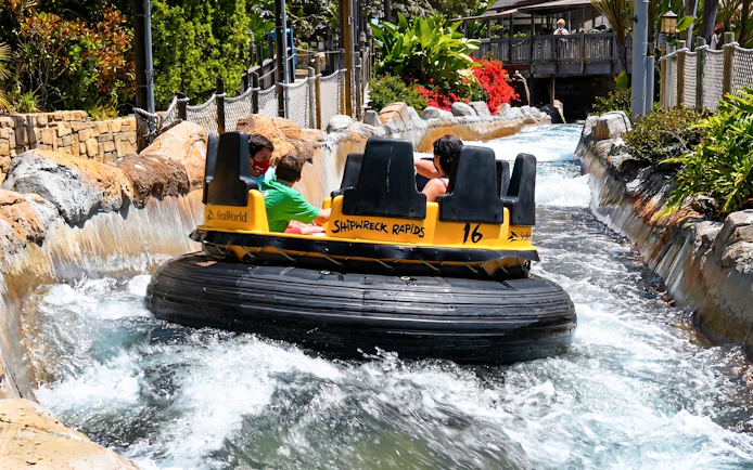 Visitors on Shipwreck Rapids ride at SeaWorld San Diego navigating water rapids.