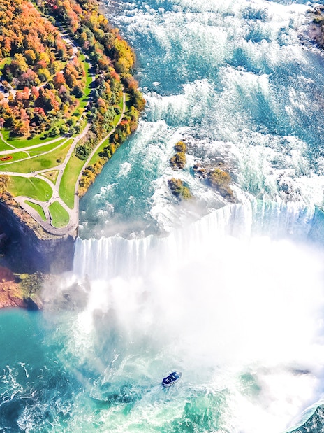 Aerial view of Niagara Falls with cascading water and mist, highlighting the surrounding landscape.