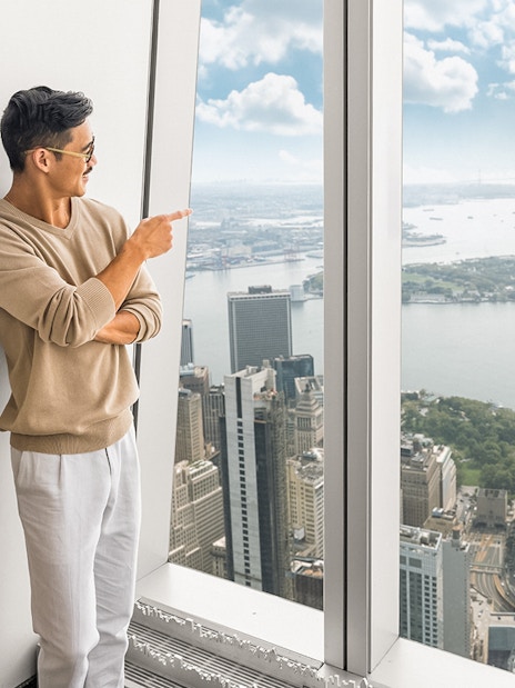 Tourists enjoying 360° views of New York City from One World Observatory.