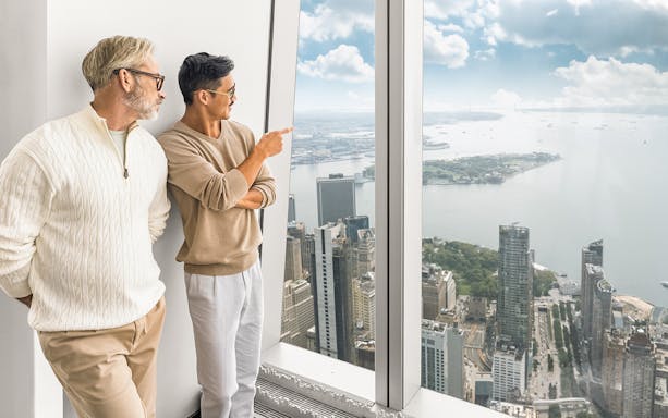 Tourists enjoying 360° views of New York City from One World Observatory.