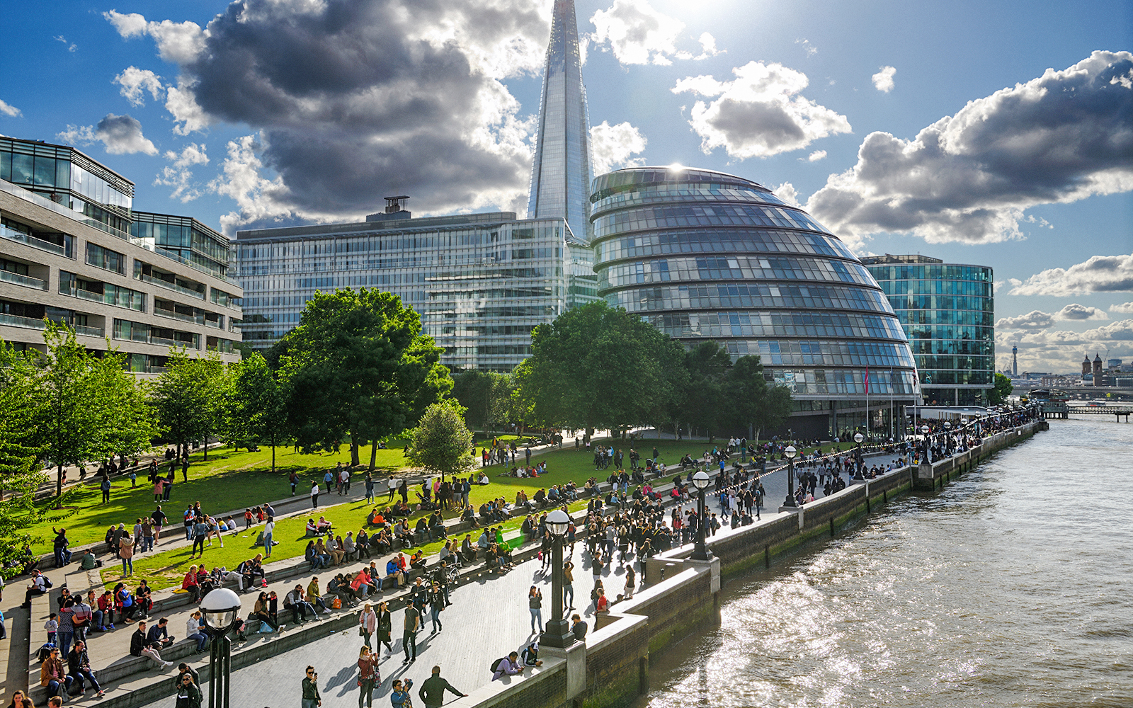 Crowds enjoying Potters Fields Park with the Shard and City Hall in the background, London.