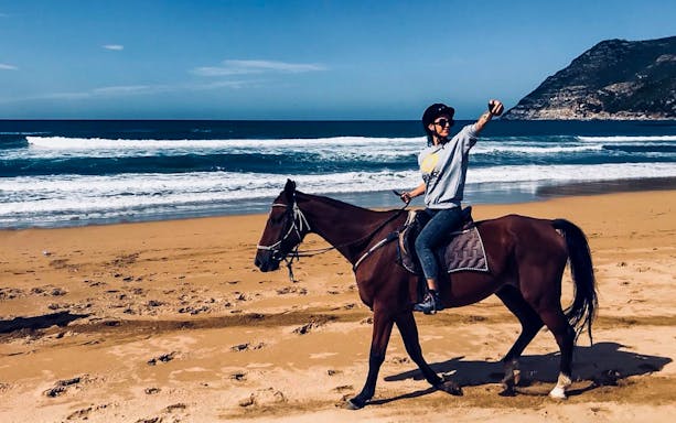 Horseback riding on Porto Ferro beach with ocean view.