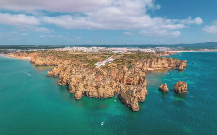 Aerial view of Algarve coastline with cliffs and turquoise waters, Portugal.