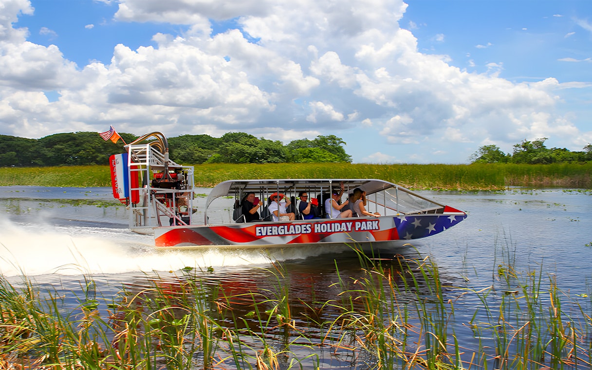 Airboat tour at Everglades Holiday Park with passengers exploring wetlands.