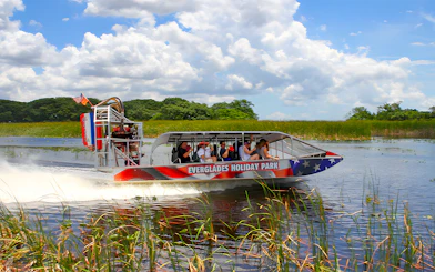 Airboat tour at Everglades Holiday Park with passengers exploring wetlands.