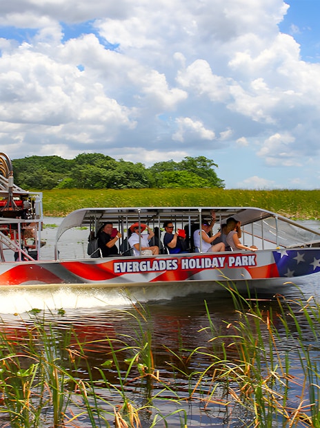 Airboat tour at Everglades Holiday Park with passengers exploring wetlands.