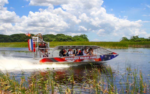 Airboat tour at Everglades Holiday Park with passengers exploring wetlands.