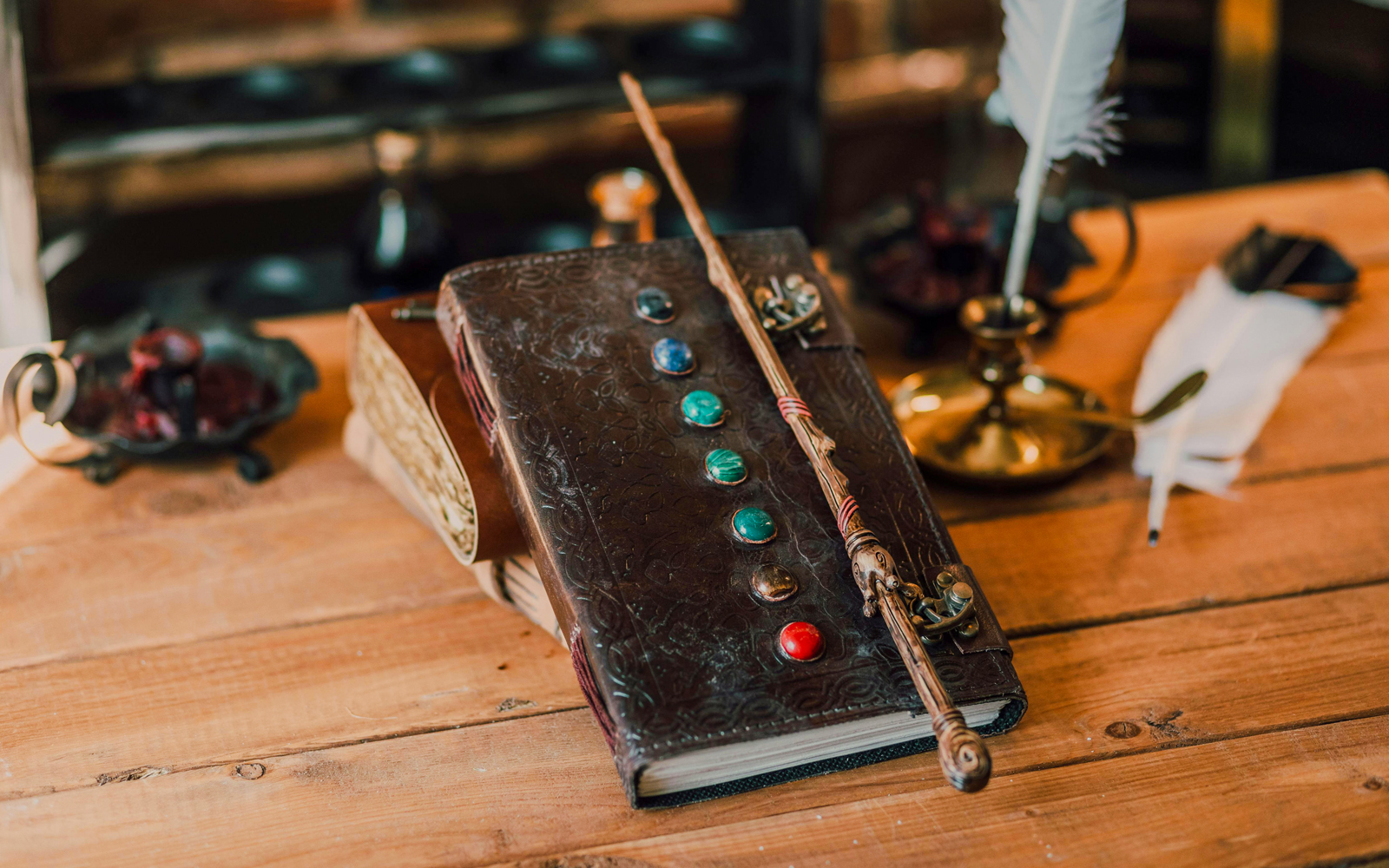 Wand resting on an open book in a magical setting