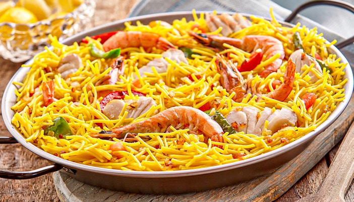 Seafood paella with noodles served in Barcelona, highlighting local cuisine in February.