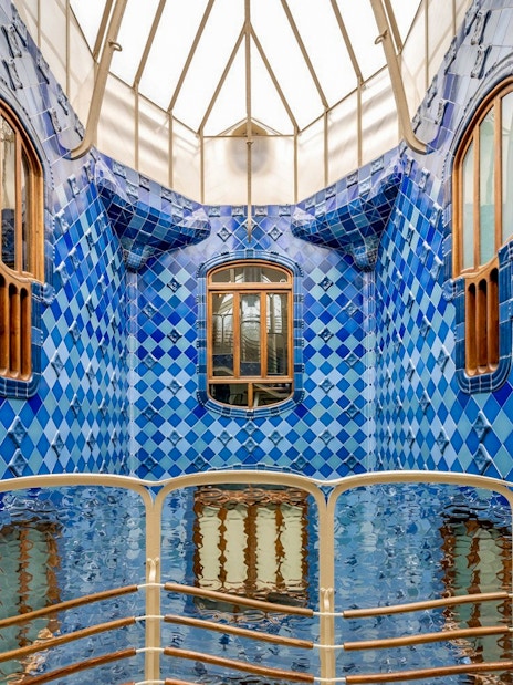 Casa Batlló interior with blue tiled walls and wooden windows, Barcelona.