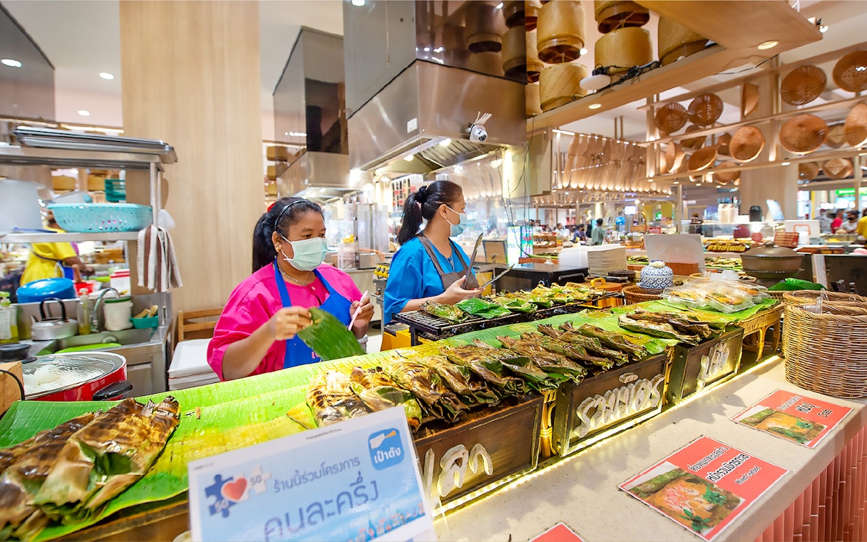 Vendors grilling fish at Ayutthaya Floating Market food stall.