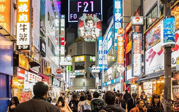 Shibuya street bustling with people and neon signs during the Best of Shibuya Food Tour.
