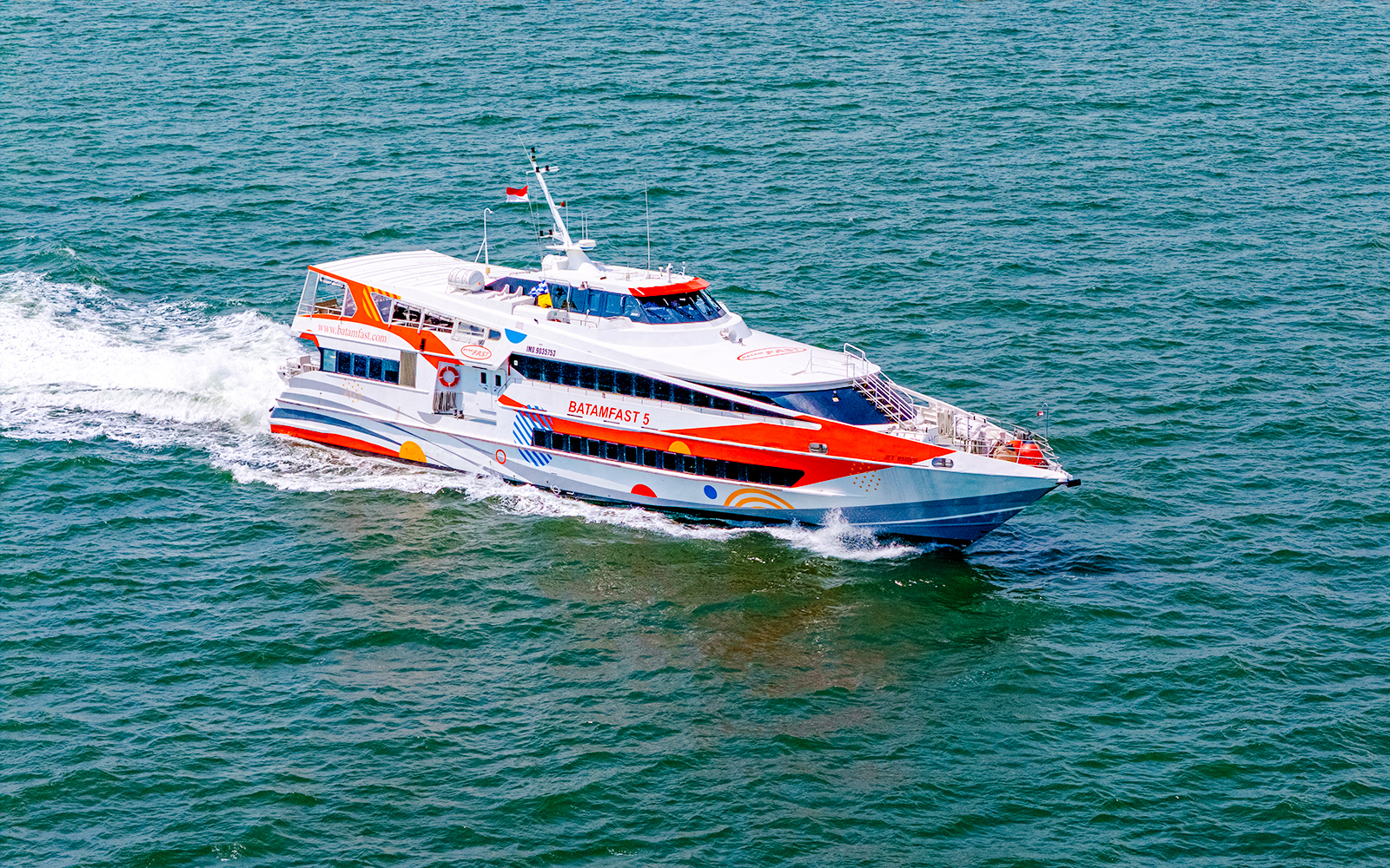 High-speed ferry traveling from Singapore to Batam across the sea.