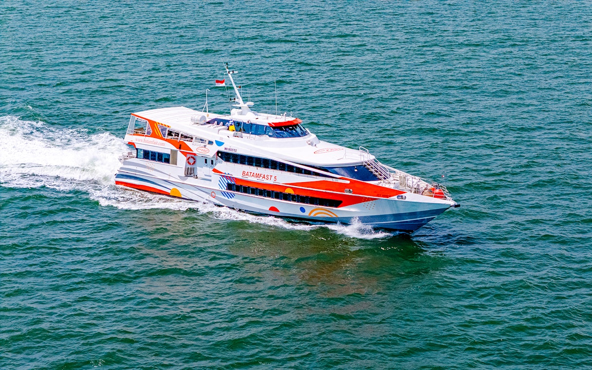 High-speed ferry traveling from Singapore to Batam across the sea.
