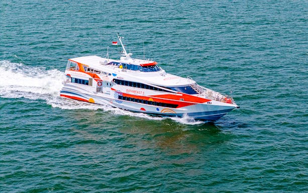 High-speed ferry traveling from Singapore to Batam across the sea.