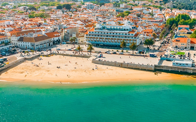 Aerial view of Cascais bay with boats and beach, Portugal.