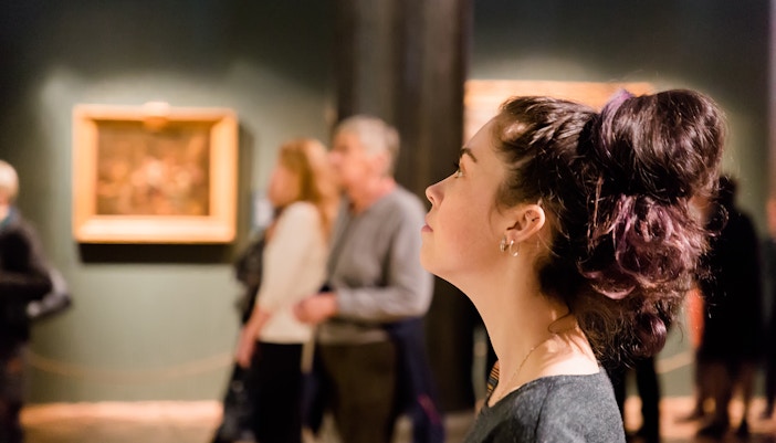 Young women waching arts at the museum. Excursion with group