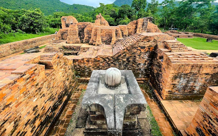 Ancient brick ruins at My Son Sanctuary, Vietnam, surrounded by lush greenery.