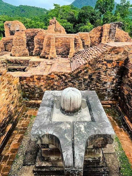 Ancient brick ruins at My Son Sanctuary, Vietnam, surrounded by lush greenery.