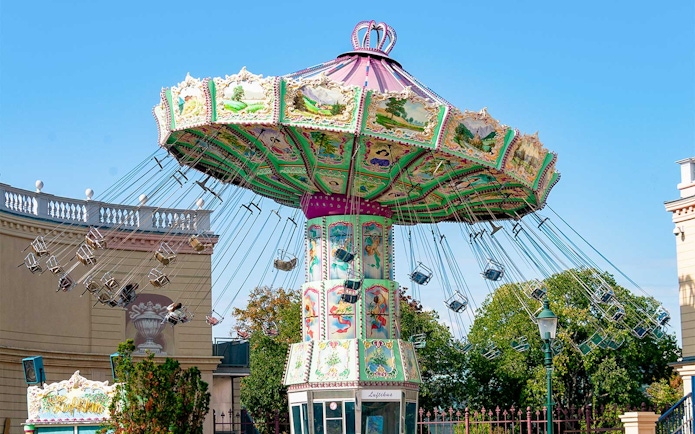 Carousel ride at Hirakata Park with colorful decorations and empty swing seats.