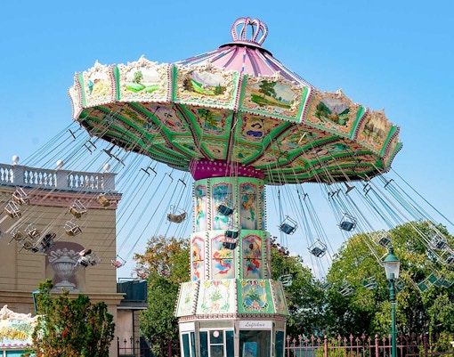 Carousel ride at Hirakata Park with colorful decorations and empty swing seats.
