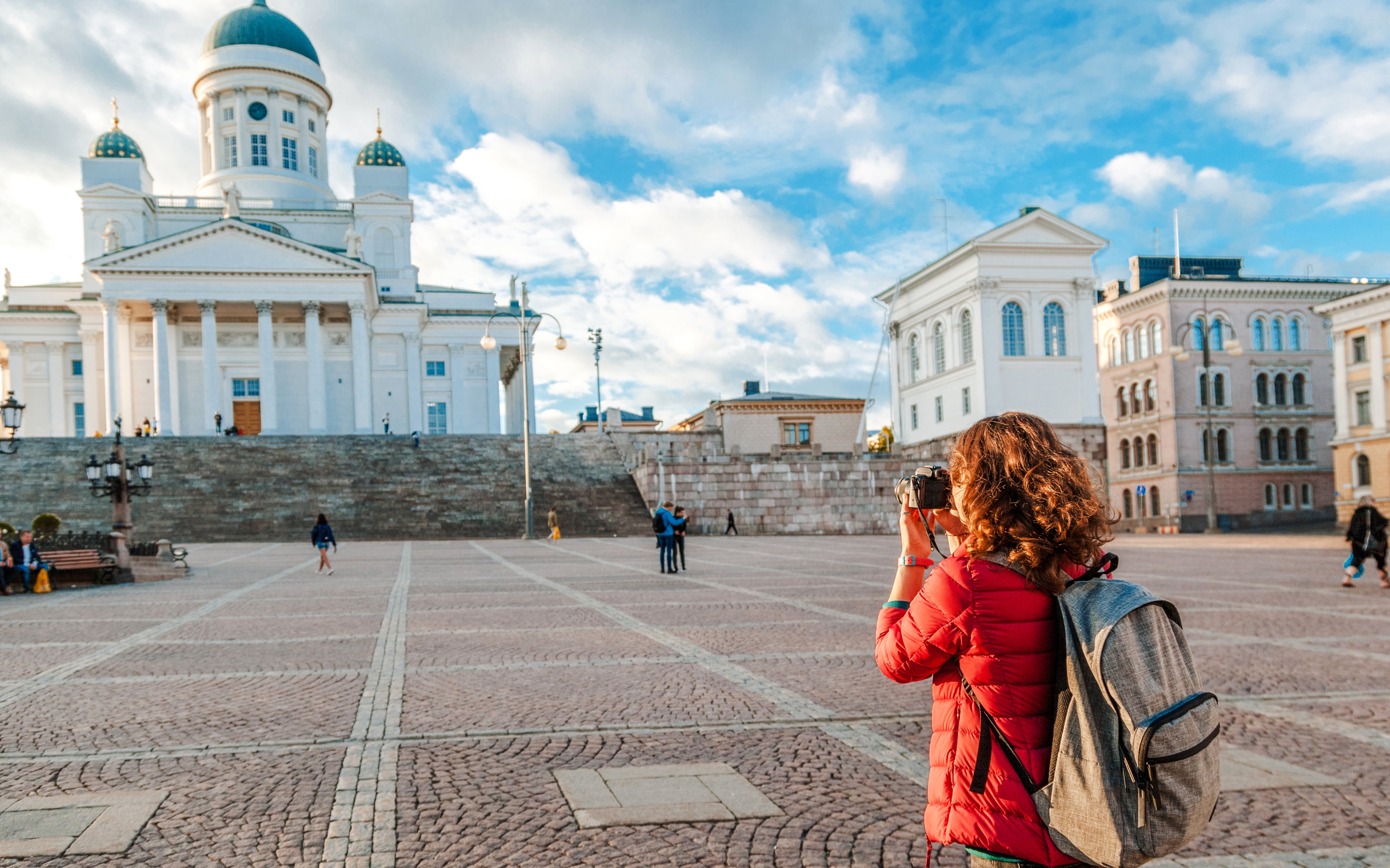 Mulher fotografando a Catedral de Helsínquia na Praça do Senado.