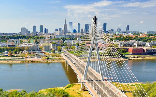 Warsaw skyline with Świętokrzyski Bridge over Vistula River, part of guided tour with hotel transfers.
