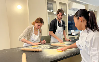 Participants making pasta in a Florence cooking class.