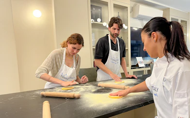 Participants making pasta in a Florence cooking class.