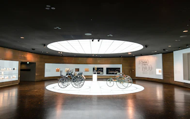 Historic vehicles displayed inside Mercedes Benz Museum.