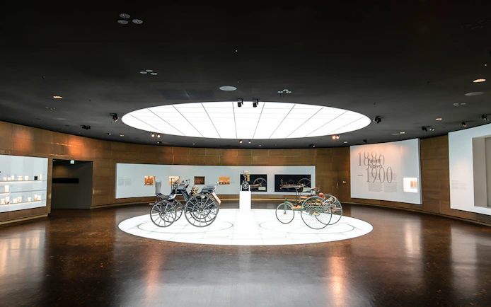 Historic vehicles displayed inside Mercedes Benz Museum.