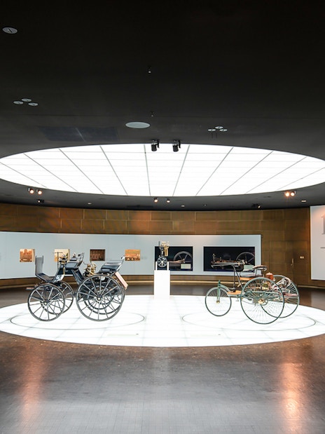 Historic vehicles displayed inside Mercedes Benz Museum.