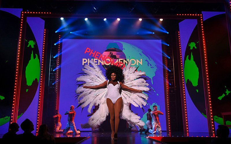 Performer on stage at RuPaul's Drag Race LIVE! Vegas show with feathered costume.
