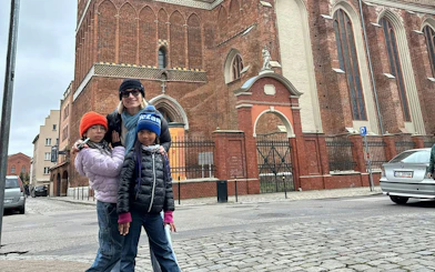 Family exploring historic brick church in Gdansk during self-guided city game.