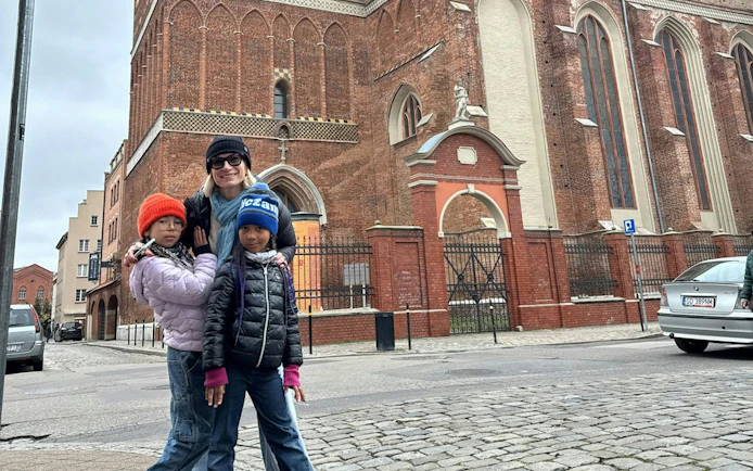 Family exploring historic brick church in Gdansk during self-guided city game.