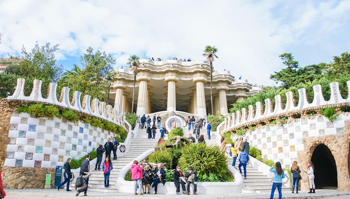 View of Barcelona cityscape from Park Guell, featuring colorful mosaic structures.
