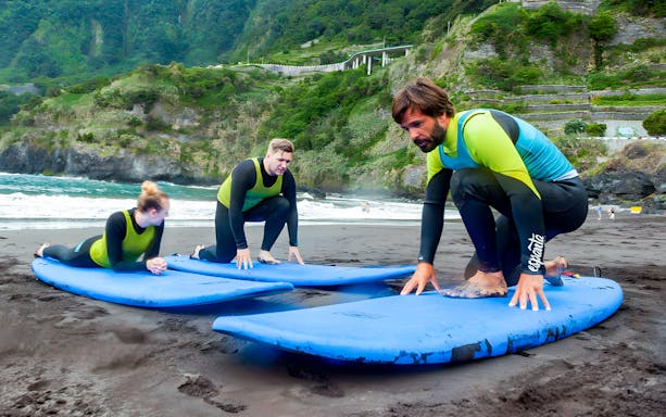 Surf instructor guiding students on a beach in Madeira, Portugal.