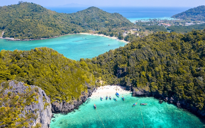 Aerial view of Maya Bay, Phi Phi Island, with boats and turquoise water, part of Phuket Sunset Tour.