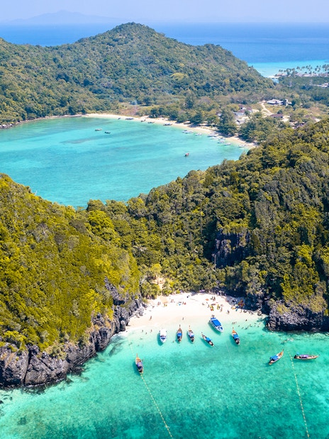 Aerial view of Maya Bay, Phi Phi Island, with boats and turquoise water, part of Phuket Sunset Tour.