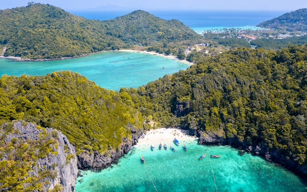Aerial view of Maya Bay, Phi Phi Island, with boats and turquoise water, part of Phuket Sunset Tour.