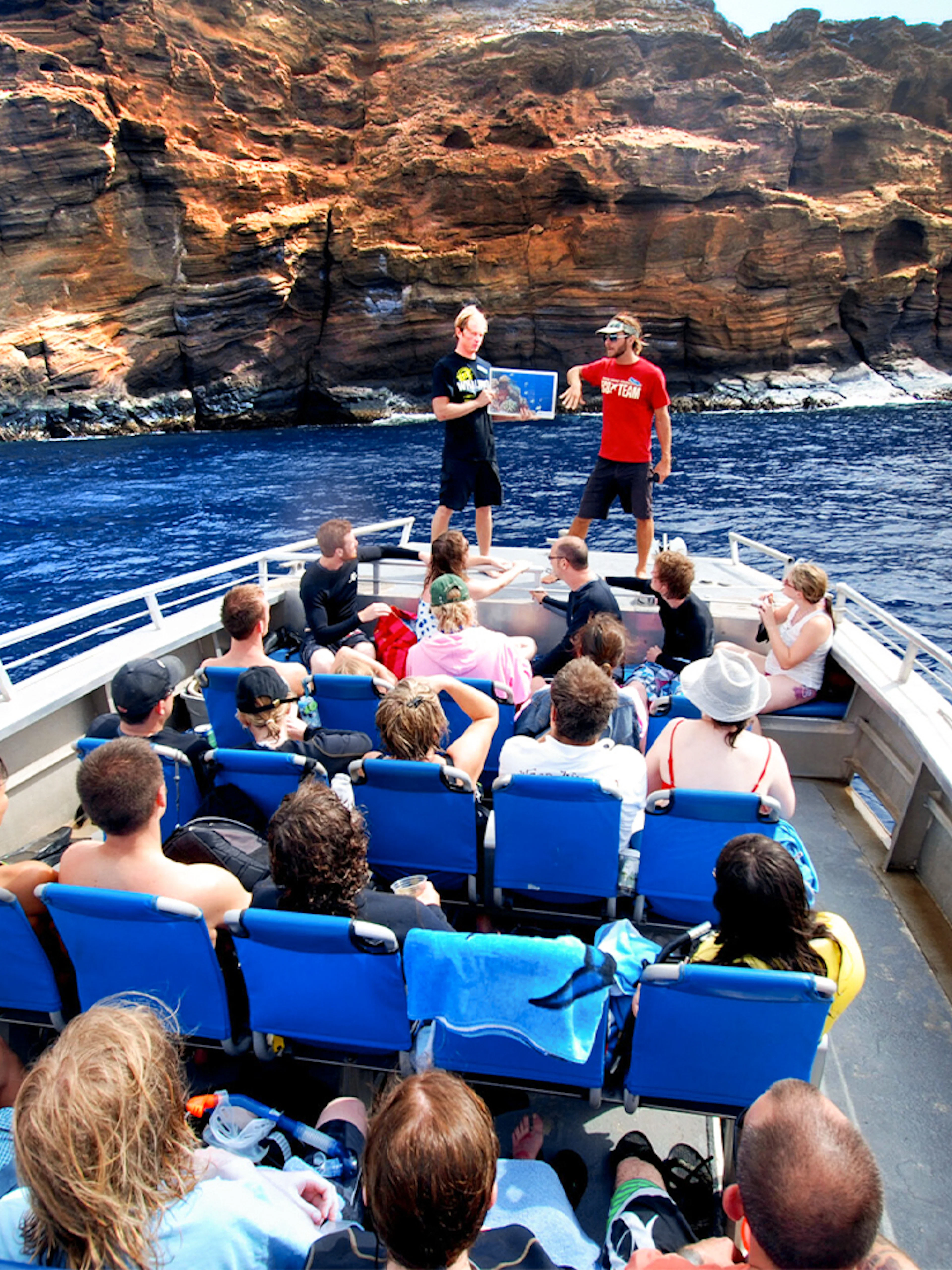 Tourists on a raft near Molokini Crater, Maui, Hawaii, listening to a guide.
