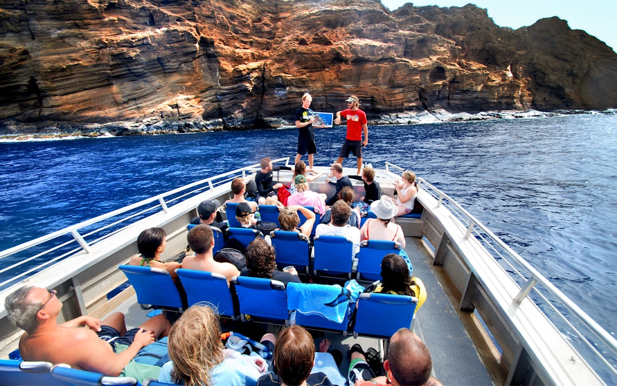 Tourists on a raft near Molokini Crater, Maui, Hawaii, listening to a guide.