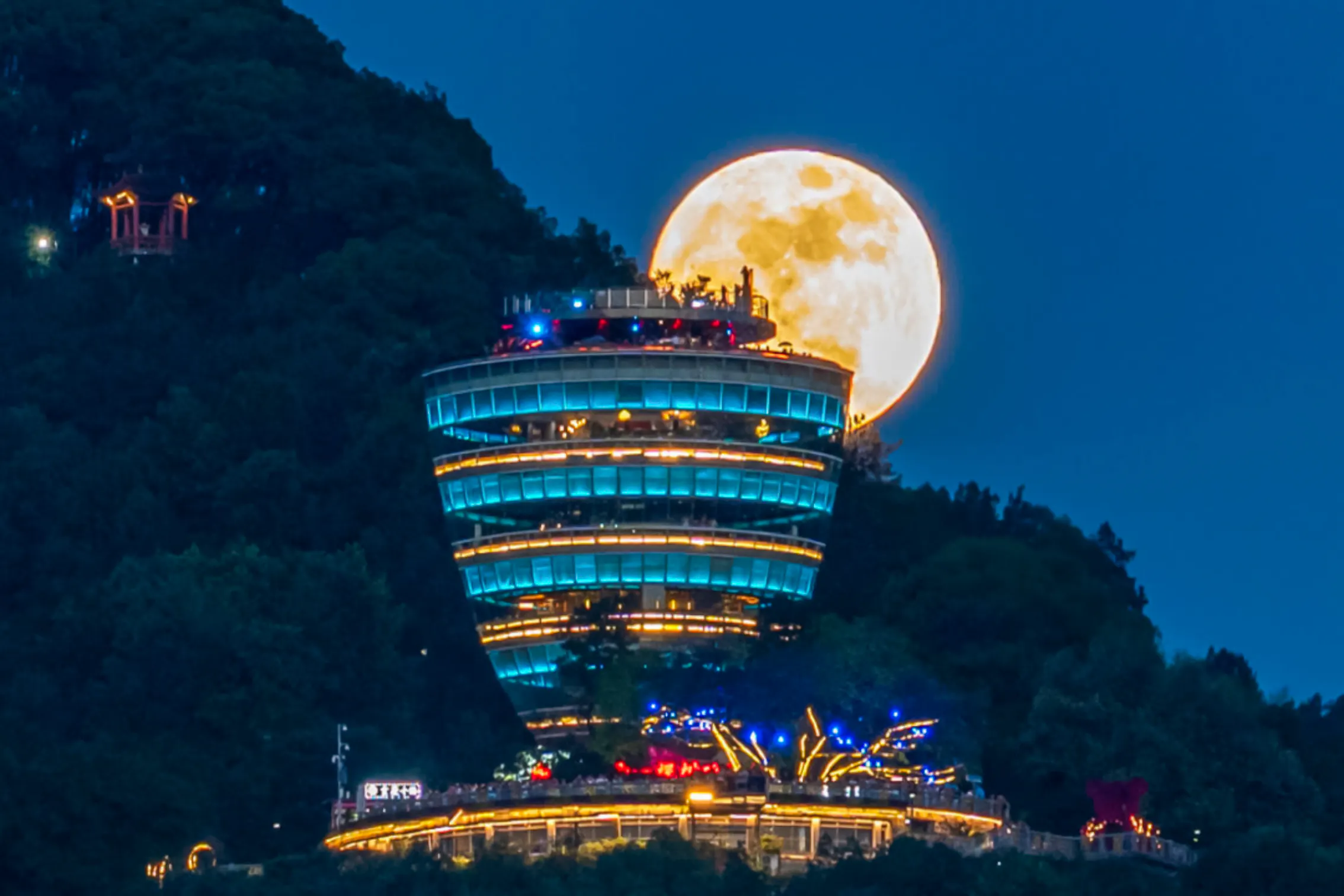 Chongqing Nanshan OneTree night view with illuminated tower and full moon.